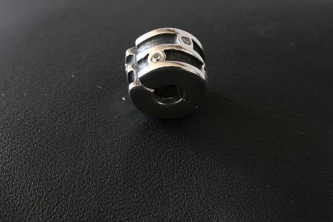 Charm for bracelets, from Pandora made as a cylinder with a pattern with inlaid, 
clear white stones. 925 sterling silver.